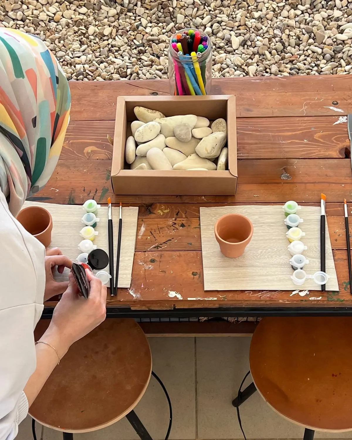 A workshop table set with stones, paints and brushes